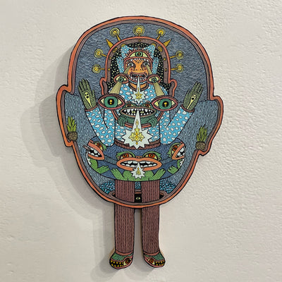 Illustrated wood cut of a humanoid with many eyes being beamed out from its head, wearing a sweater and inflatable tube with monsters on it. He stands within a hollow human head, his legs poking out the bottom.