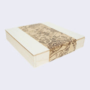 Unstained wooden box with a paper wrap around, featuring a series of illustrations of a stoic looking woman with many mechanical parts coming from her body.