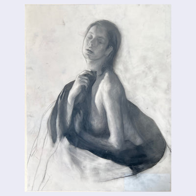 Soft charcoal nude of a woman with eyes closed and a black blanket wrapped around herself.