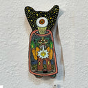 Illustrated wood cut of a green goblin trapped within a confined dome, an eye beaming out of its forehead, into a night sky with lots of stars.