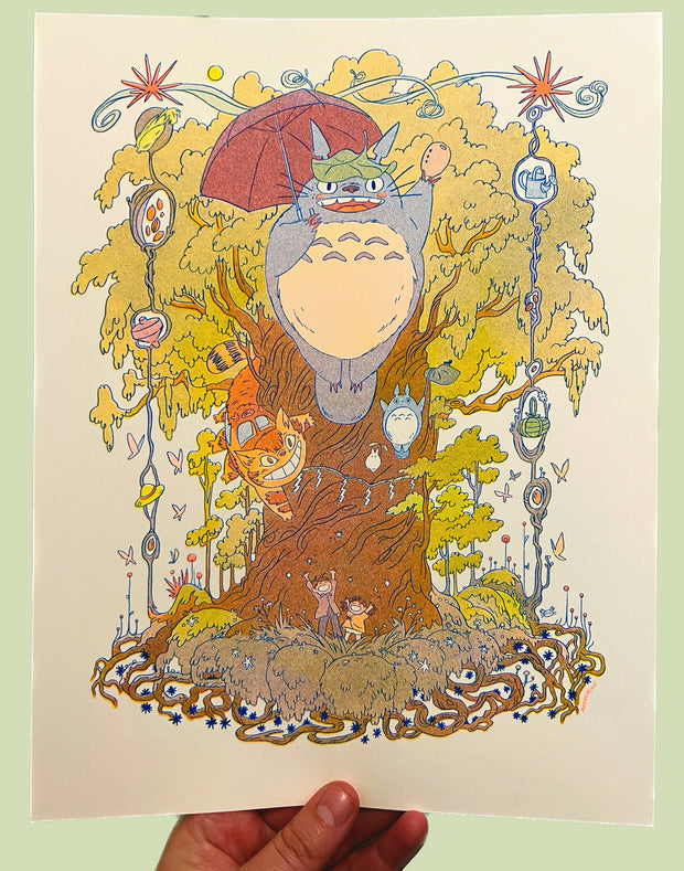 Risograph print of a colorful, energetic scene of a large tree with Totoro in front of it, flying with a red umbrella. Catbus wraps around the tree, smiling and two children excitedly stand with their arms up at the bottom of the tree.