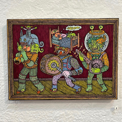 Illustration on wood of 3 monster creatures playing instruments in a line, like a parade. One is flanked with smaller animals, one has a man sleeping in a bed on their head, the other's head is inside of a fish bowl with a goldfish swimming around.