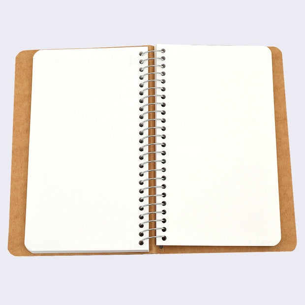 Open spread of spiral ring notebook, revealing white blank pages.