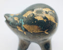 Rounded deep teal ceramic sculpture of a quadruped with a wide goofy smile. Gold fish swim on its body with splatters of blue.