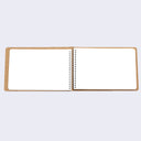 Open spread of spiral ring notebook, revealing white blank pages.