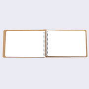 Open spread of spiral ring notebook, revealing white blank pages.