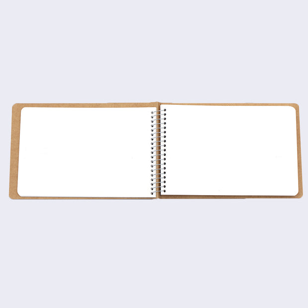 Open spread of spiral ring notebook, revealing white blank pages.