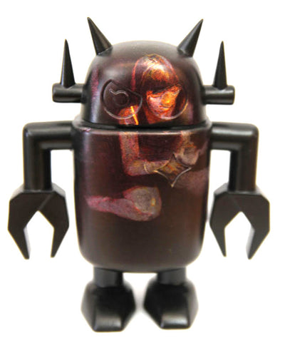 Robot vinyl toy with painting of a girl sitting on the ground, looking at something in their hands