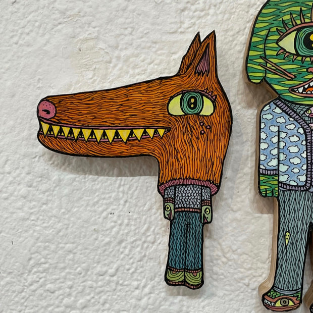 Illustrated wood cut of a little humanoid with a patterned sweater and pants wearing a large brown werewolf heat, with an exaggerated long snout and sharp yellow teeth.