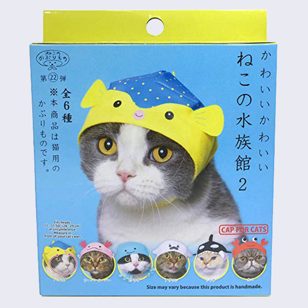 Blue and yellow blind box packaging, with a gray and white cat wearing a snug cap designed like a pufferfish. 6 total designs are at the bottom, detailed on next photo. Japanese script is on the box.