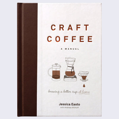 Book cover, all white with a thick brown spine coloring. 3 small illustrations of different coffee machines are under the title, which is in impressed copper font.