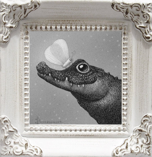 A finely detailed illustration of a semi-cartoonish crocodile, smiling kindly up at a large moth on its snout. Illustration is greyscale and maintains a slightly fuzzy visual feature and is in an ornate white wooden frame.