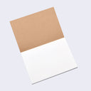 Open view of sketchpad, with back of kraft brown cover and blank white paper.