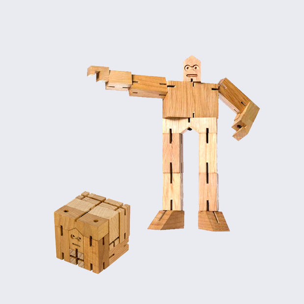 Wooden robot made out of many geometric parts, joined together tightly by strings so arms and legs are moveable. 