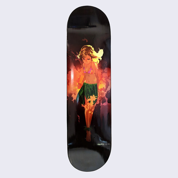 All black skateboard deck with an illustration of an angry looking girl, wearing a bathing suit top and grass skirt, with blonde hair that is being lit up by flames and smoke behind her.