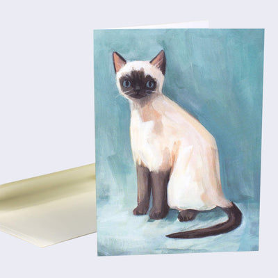 The front of note card is shown with an envelope behind it. The notecard has an illustration of Siamese cat with a curious expression.