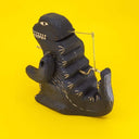 Back view of carved wooden sculpture of a black Godzilla.