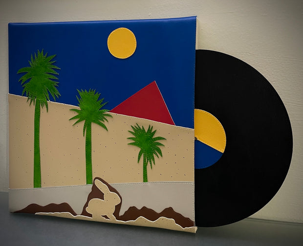 Vinyl (pleather) recreation of The Cure's "Boys Don't Cry" album cover, with a pleather black record peeping out from the sleeve. Cover features a rabbit, underground below 3 green palm trees, a simple red pyramid, a blue sky and a yellow sun.