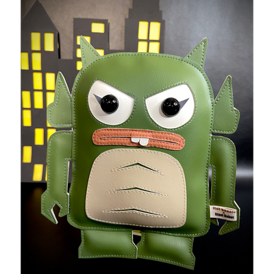 Vinyl plush of a green Monster of the Black Lagoon-esque character, shaped as a Big Boss Robot figure. Two buck teeth stick out of a closed mouth, with angry eyes. A paper cut out city is in the background.