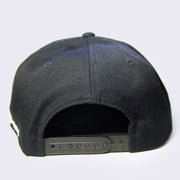 Back of black hat with a snap closure for size adjustment.