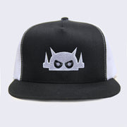 Front view of black baseball cap. Robot head is stitched on with white thread. Its eyes are black but with white pupils.
