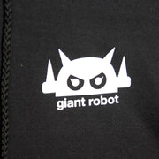 Close up of a small white graphic on a black jacket, a robot head above text that reads "giant robot" in lowercase white font.