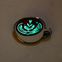 Enamel pin of a latte cup, glowing in the dark.
