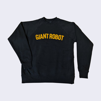 Black crewneck long sleeve sweatshirt with "Giant Robot" embroidered yellow letters written across the chest, in the upper center of the sweater.