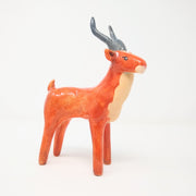 Ceramic sculpture of an orange elk with a cream colored chest and snout, with curved gray antlers.