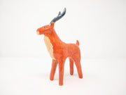 Ceramic sculpture of an orange elk with a cream colored chest and snout, with curved gray antlers.