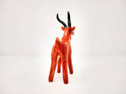 Ceramic sculpture of an orange elk with a cream colored chest and snout, with curved gray antlers.