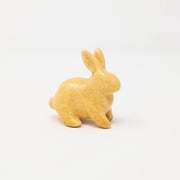 Yellow ceramic bunny with no facial features.