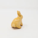 Yellow ceramic bunny with no facial features.