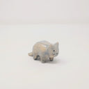Small grey and white ceramic sculpture of a slightly chubby cat, standing on 4 legs with minimal shape details. It has a simplistic painted on cat face with whiskers.