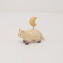 Small ceramic sculpture of a painted Siamese coloring cat, with simplistic body shapes and a drawn on face. Attached with a wire coming out of its back is a ceramic yellow crescent moon.
