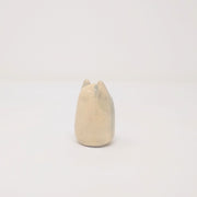 Small oval shaped cream color ceramic sculpture with little ears. It has a drawn on growling face.