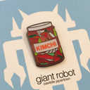 Close up of kimchi enamel pin on a blue backing card.