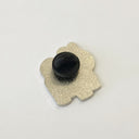 Back of enamel pin with a rubber pin backing.