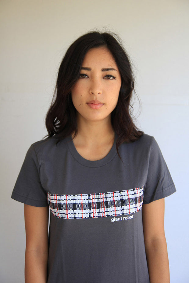 Person wearing grey t-shirt. A plaid pattern in red, white, and black goes across front chest of t-shirt. Small text below says giant robot.