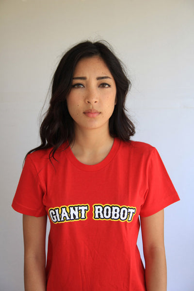 Person wearing red t-shirt. Front of t-shirt has bold white text across chest that says giant robot. Text is outlined in black and yellow.