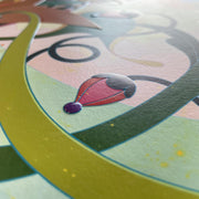 Detail photo of a colorful illustration of a semi anthropomorphic character with a flower hat and patterned kimono sitting, reading a book. Photo shows dimensionality and sheen of print.