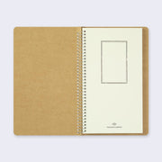 Open spread of spiral ring notebook, revealing title page. Cream colored paper with black vertical rectangle. 