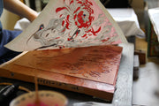 "Chrysanthemum" being pulled from its woodblock after printing.