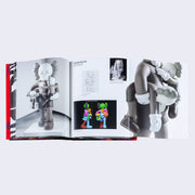 Open two page book spread with fold out page, featuring photographs of Kaws sculpture of a figure carrying two children figures in each arm.