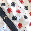 Close up of the tiny red and black robot pattern. Tiny red hearts and black diamonds are scattered between the robots.