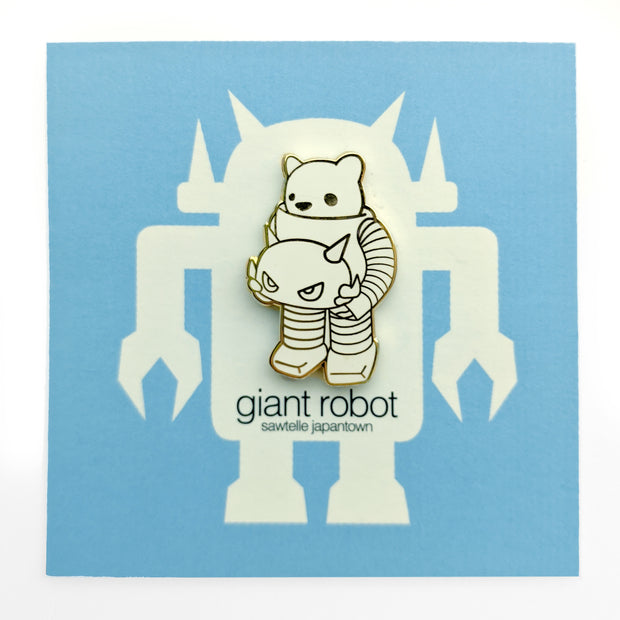 Enamel pin of a white bear inside a robot suit, holding the robot's head in its hands. Only visible part of the bear is its head. Pin is white with gold outlines.