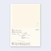 Cream colored notebook cover with a paper sleeve wrapped around with details about the notebook in English and Japanese.