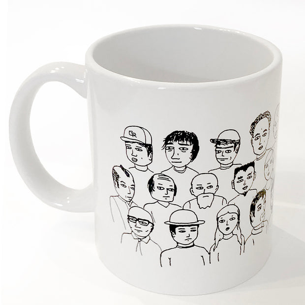 White ceramic mug with various line art cartoon people, upper bodies and faces showing only.