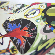 Detail photo of a book page, displaying a character with make eyes, shapes, colorful patterns and pointy black teeth.