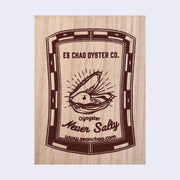 Wooden rectangle box with a patterned border, within text reads "ES Chao Oyster Co." in all caps over an illustration of a happy oyster popping out of its shell. "Oyoyster Never Salty" is written below illustration.
